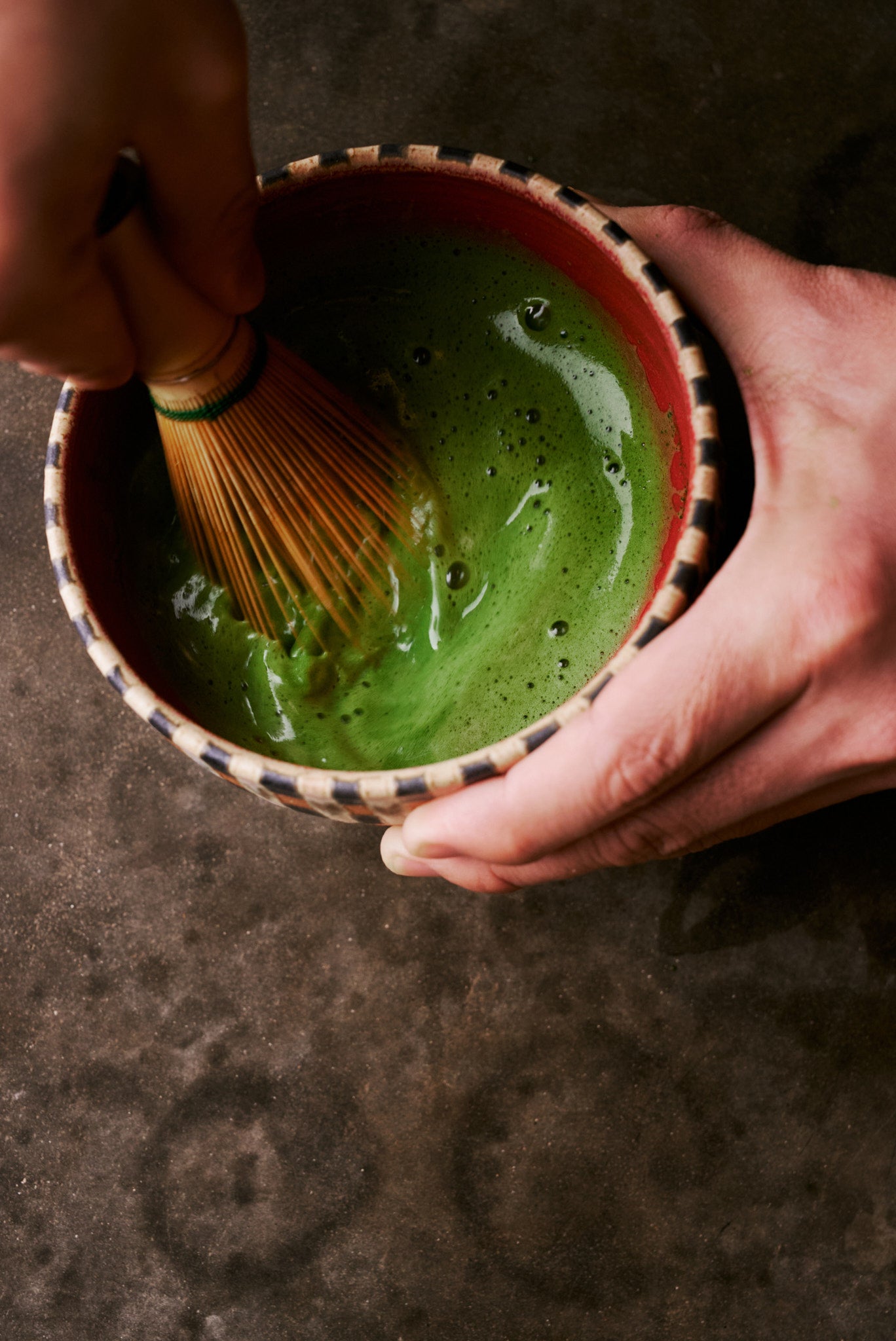 Preparing matcha in handcrafted HIRAGOUSHI bowl - whisking with chasen held in hand